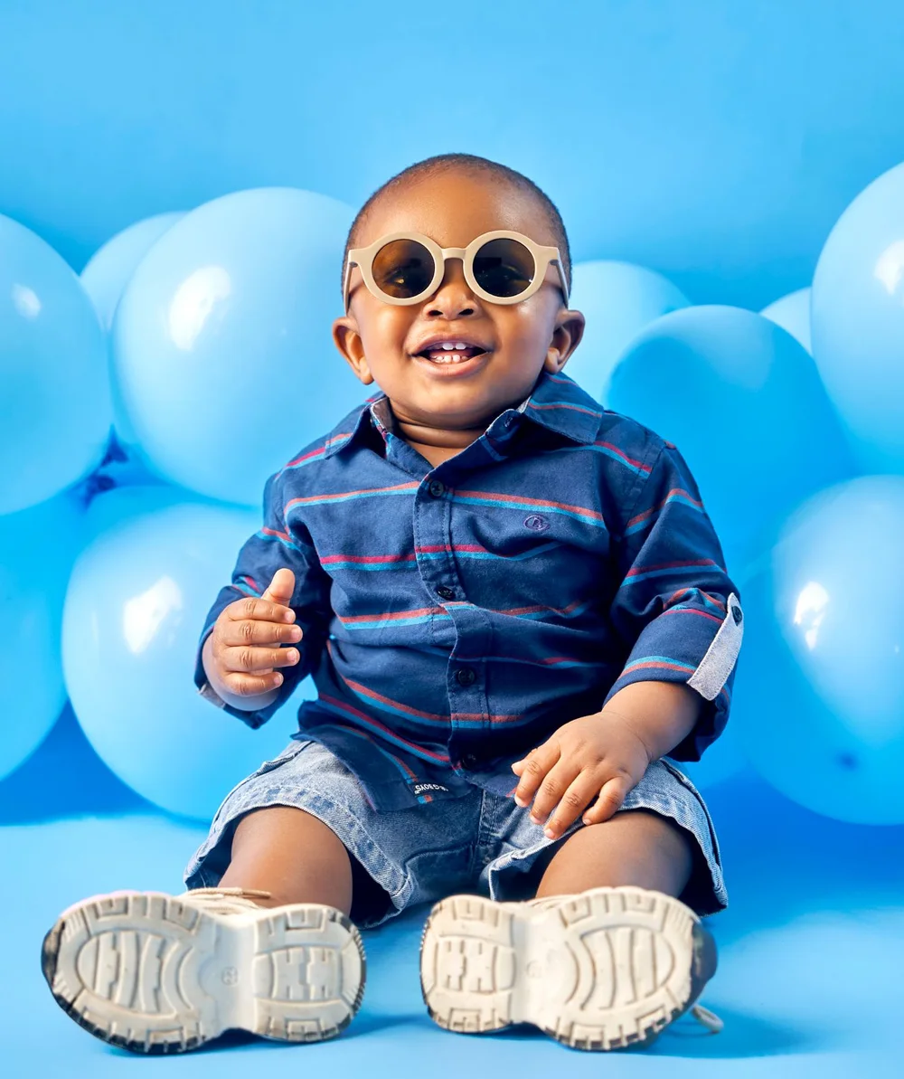 Smiling baby wearing cream sunglasses