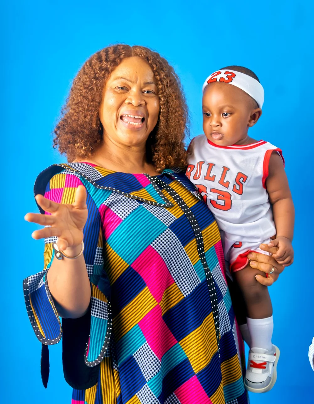 A woman smiling while holding a young child